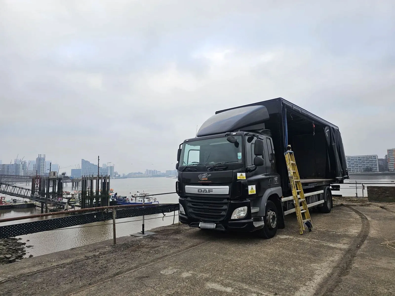 A large truck parked next to a body of water.