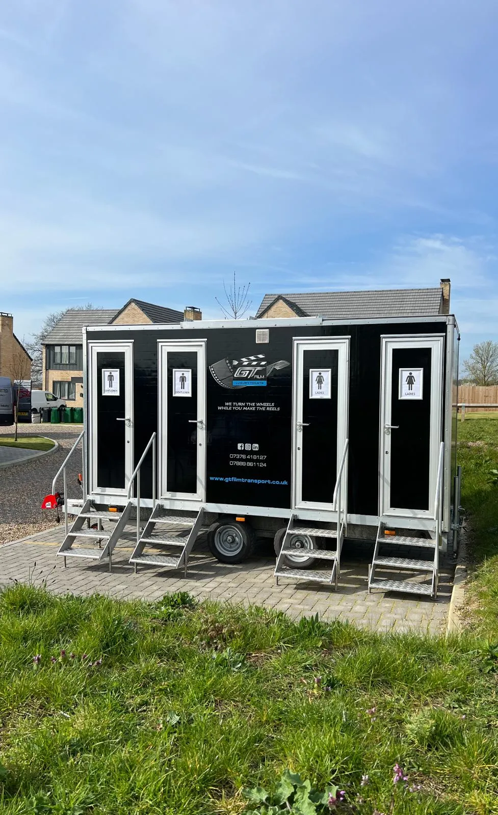 A couple of portable toilets sitting on top of a lush green field.